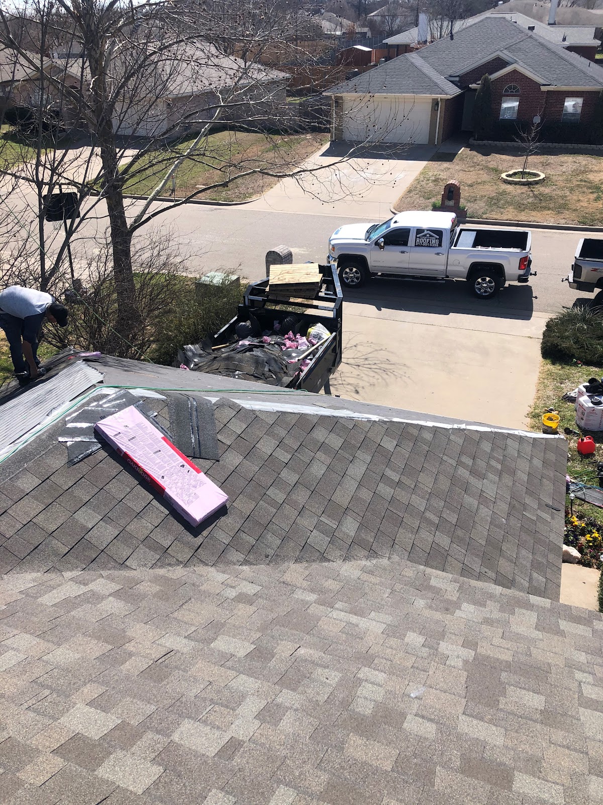 Aerial view of the crew working on a rooftop with the company truck below